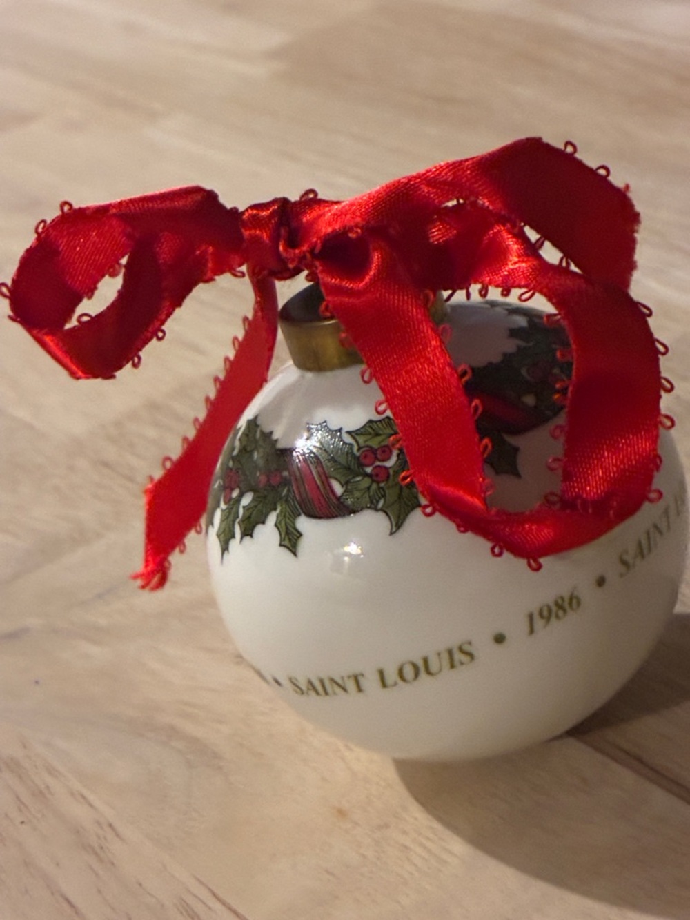Saint Louis Crystal white porcelain ornament with red ribbon and holly motif